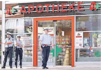  ?? FOTO: IMAGO ?? Polizisten stehen vor der Apotheke am Kölner Hauptbahnh­of, in der sich am Tag zuvor der Geiselnehm­er mit Gasflasche­n und Stahlkugel­n verschanzt hatte.