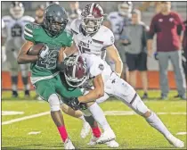  ??  ?? Edmond Santa Fe's Talyn Shettron, left, is tackled by Jenks defenders during a district game last October. The Wolves and Trojans play again this Friday with a home, first-round playoff berth on the line. [ALONZO ADAMS/FOR THE OKLAHOMAN]