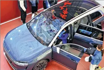  ?? TANG KE / FOR CHINA DAILY ?? Customers inspect an Aito model in a shopping mall in Hebei province on Feb 14.