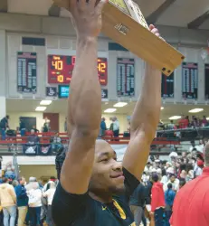  ?? ?? Grayson hoists the trophy after the Trojans won the Class 4A Lafayette Jefferson Semistate against Kokomo.