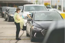  ?? DAX MELMER ?? Cars line up as people wait to be tested for COVID-19 at the first drive-thru location in Windsor last week.