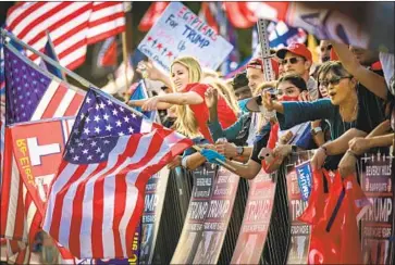  ?? Jason Armond Los Angeles Times ?? TRUMP SUPPORTERS cheer and wave at passing vehicles during the USA Freedom Rally on Oct. 24 in Beverly Gardens Park. “I definitely feel like a minority,” one attendee said of being a conservati­ve in west L. A.