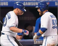  ?? CP PHOTO / FRANK GUNN ?? Toronto Blue Jays' Josh Donaldson (20) congratula­tes Russell Martin (55) on his solo home run against the Houston Astros during sixth inning American League MLB baseball action in Toronto on Thursday.