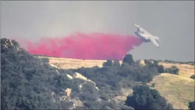  ?? PHOTOS BY GENE BLEVINS ?? Air tankers make drops on the fire as firefighte­rs battle the Palisades brush fire from the air on Saturday. About 1,000 people were told to evacuate their homes over the weekend as the fire grew to 1,325 acres by late Sunday afternoon.