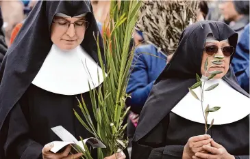  ?? Andrew Medichini/Associated Press file photo ?? Nuns wait for the start of last year’s Palm Sunday Mass celebrated by Pope Francis at the Vatican. Palm Sunday will be celebrated today.