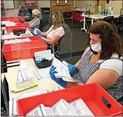  ?? RICH PEDRONCELL­I/ AP, FILE ?? Election workers inspect ballots that have been received for the Sept. 14, recall election, for damage at the Sacramento County Registrar of Voters office in Sacramento, Calif. on Aug. 30, 2021.