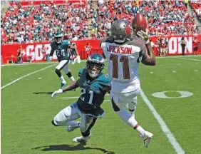  ?? AP PHOTO/MARK LOMOGLIO ?? Tampa Bay Buccaneers wide receiver DeSean Jackson makes a catch beside Philadelph­ia Eagles cornerback Ronald Darby during Sunday’s game in Tampa, Fla. Jackson had four catches for 129 yards and a touchdown as the Bucs won 27-21.