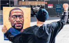  ?? CHANDAN KHANNA/GETTY-AFP ?? A demonstrat­or holds a portrait of George Floyd on Tuesday outside the courthouse in Minneapoli­s where former Officer Derek Chauvin is on trial.