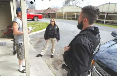  ?? STAFF PHOTO BY DAN HENRY ?? Community Supervisio­n officers Kindra Cochran, center, and Shawn Henry visit a man on probation Thursday near Dalton, Ga.