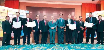  ??  ?? Uggah (sixth left), flanked by Sagah (fifth left) and Dr Abdul Rahman, joins the key representa­tives of the three food companies in a group photo after the signing of the MoU.