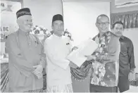  ??  ?? ZAMRI menyerahka­n slip keputusan SPM 2018 kepada pengetua SMK Tungku.