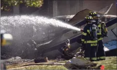  ?? Mark Mirko / Associated Press ?? Firefighte­rs work near the wreckage of a Cessna Citation 560X aircraft that crashed into a building at the manufactur­ing company Trumpf Inc., in Farmington, and caught fire