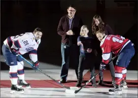  ?? Herald photo by Greg Bobinec @GBobinecHe­rald ?? Jonah Stuckart, 2018 Youth Dream Bursary Recipient, drops the puck with David Gabert and Tara DeHeer from Canadian Mental Health Associatio­n for Lethbridge Hurricanes’ Jordy Bellerive, right, and Regina Pats’ Brady Pouteau for the mental health home game, Tuesday night at the Enmax Centre.