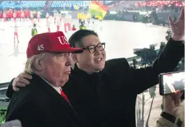  ?? CARL COURT/GETTY IMAGES ?? Above: Lookalikes of U.S. President Donald Trump, left, and North Korean leader Kim Jong Un at the opening ceremonies. Right: U.S. Vice-President Mike Pence, front, watches the ceremonies. Kim Jong Un’s sister, Kim Yo-jong, is at back right.