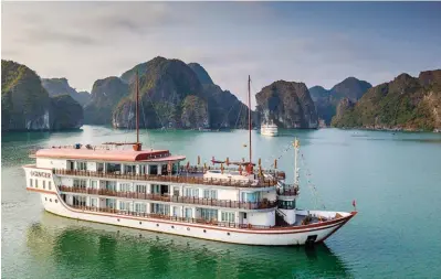  ??  ?? Plus luxueux, le bateau de croisière « Ginger », un troisponts de 57 mètres gouverné par le capitaine Tran Xuan Tho (ci-dessus), dispose de 12 cabines spacieuses avec balcon.