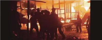  ?? [FOTO HAZSHAH ABDUL RAHMAN/BH] ?? Anggota bomba memadamkan kebakaran rumah setinggan di Kampung Gelam, Jalan Leila, Sandakan, kelmarin. Dianggarka­n 35 buah rumah musnah dalam kebakaran berkenaan.