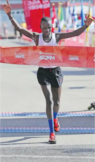  ?? GAVIN YOUNG ?? Kenyan Daniel Kipkoech, who now lives in Lethbridge, crosses the finish line to claim first-place honours at the Calgary Marathon on Sunday in a time of 2:22:33, nearly six minutes ahead of second place.