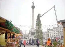  ?? Reuters ?? Workers place lights onto the Christmas tree in Trafalgar Square in London. —