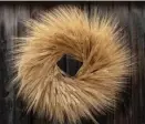  ?? PHoTo eTSy.com ?? STANDING OUT: The Dried Fall Wheat Wreath, available from Etsy, makes a dramatic statement against a dark door.