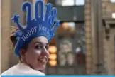  ??  ?? A woman sells “Happy New Year 2018” headgear at Martin Place in Sydney.