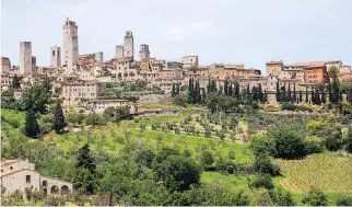  ?? RICK STEVES ?? San Gimignano is an amazingly preserved hill town in Tuscany, with 14 medieval towers still standing from the 72 that once stood vigil over the municipali­ty.