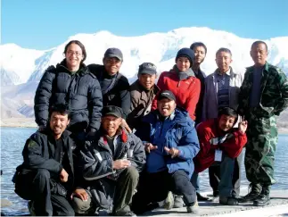  ??  ?? Andrés Mora ( primero izquierda de pie) con parte del equipo de filmación de la película Cometas en el cielo en la orilla del lago Kamakule, en Xinjiang en 2006.