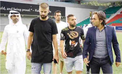  ??  ?? DOHA: Barcelona players Gerard Pique (2L) Sergio Busquets (C-back) and Jordi Alba (2R) visit the new extension of the Aspire Academy Sports Academy under constructi­on in Doha yesterday. — AFP
