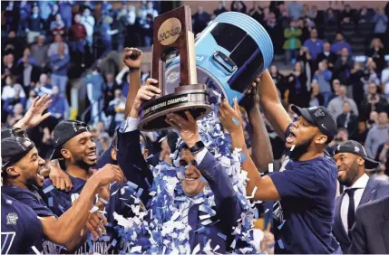  ?? GREG M. COOPER/USA TODAY SPORTS ?? Villanova players dump confetti on head coach Jay Wright after the Wildcats defeated Texas Tech on Sunday to win the NCAA tournament’s East Region championsh­ip in Boston.
