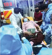  ?? AFP ?? An ambulance crew hands over a crash survivor to hospital staff in Kozhikode