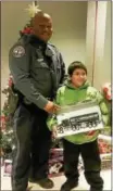  ?? CITY OF COATESVILL­E POLICE DEPARTMENT FACEBOOK PHOTO ?? Members of the Coatesvill­e Police Department issued “tickets” to youths in Coatesvill­e for “doing something right.” The tickets are holiday shopper dollars for the kids to purchase gifts for their family members. Officer Sylvester Earle poses with a...