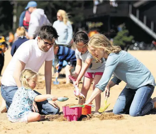  ??  ?? FUN IN THE SAND: David and Naomi Emerton with their daughters Sophie, 2, and Lois, 5, at Loch Morlich beach
