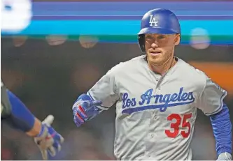  ?? AP PHOTO/TONY AVELAR ?? The Los Angeles Dodgers’ Cody Bellinger is congratula­ted after he hit a solo home run against the San Francisco Giants on Sept. 27. Bellinger won the MVP award for the National League on Thursday, when the Los Angeles Angels’ Mike Trout was named MVP of the American League for the third time.