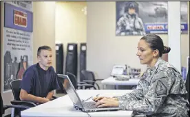  ?? BOB ANDRES / BANDRES@AJC.COM ?? Sgt. 1st Class Shanda Sellars (right) works on enlistment forms for John Greenwell, a Sprayberry High School senior, at a recruiting office in a suburban Marietta strip mall.