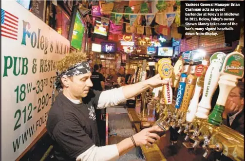  ??  ?? Yankees General Manager Brian Cashman acts as guest bartender at Foley’s in Midtown in 2011. Below, Foley’s owner Shawn Clancy takes one of the bar’s many signed baseballs down from display.