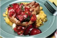  ?? Tribune News Service ?? Whiskey-brined pork chops topped with tomato-plum relish served atop sweet corn and chive polenta.