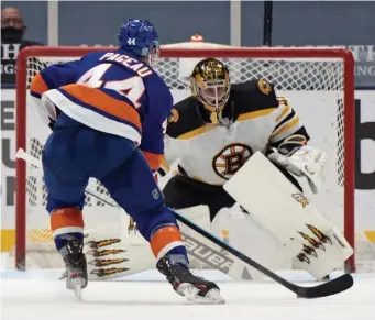  ?? Getty images pHotos ?? ROUGH NIGHT: Islanders forward Jean-Gabriel Pageau scores a third-period goal against Bruins’ goaltender Jaroslav Halak at Nassau Coliseum on Thursday in Uniondale, N.Y. At right, Boston’s Trent Frederic is checked into the boards by New York’s Noah Dobson during the first period.