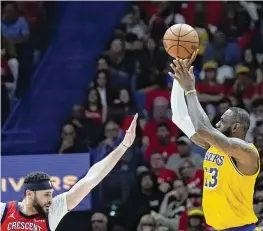  ?? AP ?? LeBron James shoots against New Orleans Pelicans forward Larry Nance Jr. in the second half of Tuesday’s play-in tournament game in New Orleans. The Lakers won 110-106, clinching a playoff spot and a series with defending champion Denver.