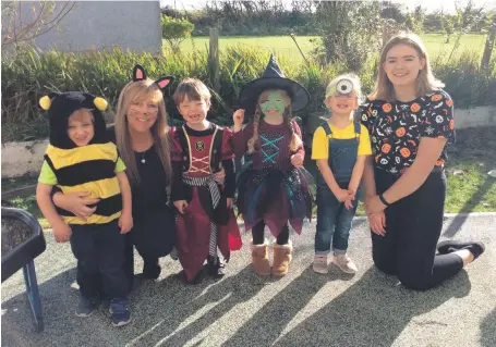  ??  ?? Wee witches, a bee and a minion join teachers at Kilmory Early Years.