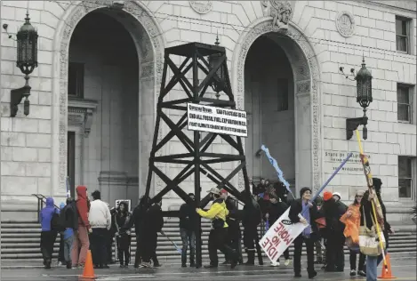  ?? AP PHOTO/JEFF CHIU ?? In this 2015 file photo, protesters prepare to take down a makeshift oil derrick that was set up in front of the California State Office Building to protest fracking in San Francisco.