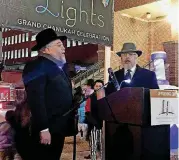  ??  ?? Rabbi Ovadia Goldman, spiritual leader of the Chabad Community Center for Jewish Life and Learning, joins Larry Davis on Sunday to lead the crowd in singing “God Bless America” to close out the 2018 “Bricktown Lights” Hanukkah event.