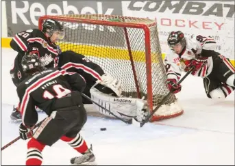  ??  ?? Tanner Pagendam (90) of the Thorold Blackhawks falls behind Niagara Falls goaltender Hunter Johnson Thursday at Thorold Arena.