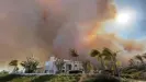  ?? Photograph: Tim Wheaton/Reuters ?? Wildfire smoke rises behind a house in Laguna Niguel, Orange county, in May 2022.