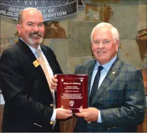  ?? Submitted photo ?? ODWC Director J.D. Strong presents a plaque to outgoing District 2 Wildlife Conservati­on Commission­er Bruce Mabrey in honor of his 20 years of service to the sportsmen and sportswome­n of Oklahoma.