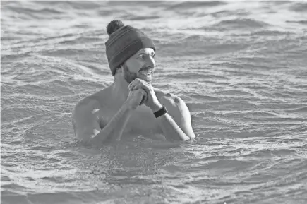  ?? PHOTOS BY MIKE DE SISTI / MILWAUKEE JOURNAL SENTINEL ?? Justin Galloway, of Whitefish Bay, takes a chilly dip in Lake Michigan at Big Bay Park on Jan. 9 in Whitefish Bay. Galloway is on a quest to jump in Lake Michigan 300 out of 365 days in a year.