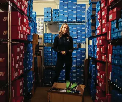  ?? Christophe­r Capozziell­o / New York Times ?? As supply chain issues in Vietnam mounted in summer and fall, Megan Searfoss says she’s been stockpilin­g sneakers for her two running shoe stores. She believes out-of-stock issues at major chains will drive customers to her stores.