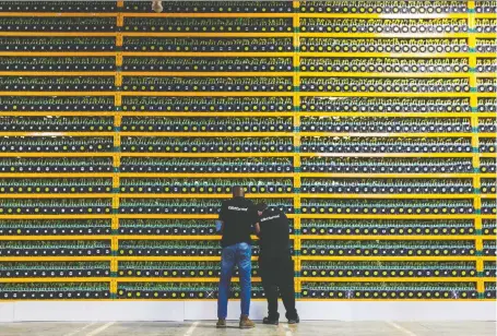  ?? LARS HAGBERG/AFP VIA GETTY IMAGES FILES ?? The Ontario Securities Commission concluded Thursday that Quadrigacx founder Gerald Cotten had caused his company’s demise through a Ponzi scheme. Above, two technician­s inspect Bitcoin mining in Saint Hyacinthe, Que.