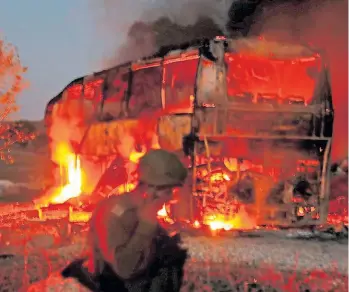  ?? AFP ?? En Israel. Los bomberos combaten el fuego en un bus israelí tras un cohete de Hamas.