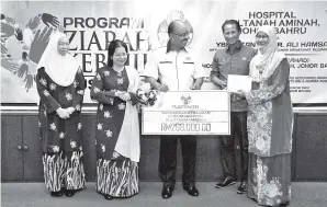  ?? GambarBERN­AMA ?? KETUA Setiausaha Negara yang juga Penasihat Puspanita Tan Sri Dr Ali Hamsa (tengah) bersama isterinya Yang Dipertua Puspanita Puan Sri Rohani Abdullah (dua, kiri) menyerahka­n sumbangan kepada Pengarah Kesihatan Negeri Johor Dr Rooshaimi Merican A Rahim...