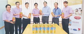  ??  ?? SOPB chief operating officer Eric Kiu Kwong Seng (third right) presents Merris cooking oil to See Hua Marketing Sdn Bhd circulatio­n executive Melvin Ng.