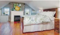  ??  ?? The master bedroom shows off its stonework and hardwood floors.